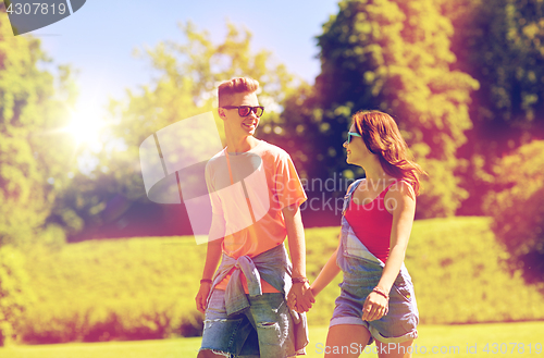 Image of happy teenage couple walking at summer park