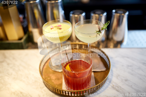 Image of tray with glasses of cocktails at bar