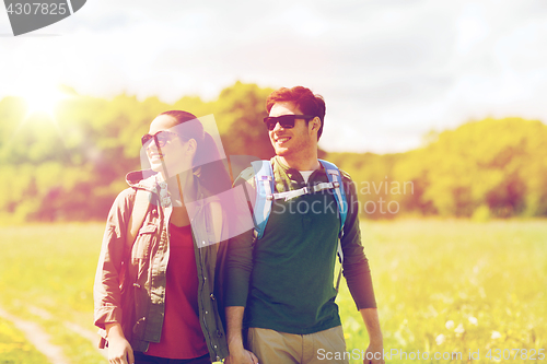 Image of happy couple with backpacks hiking outdoors