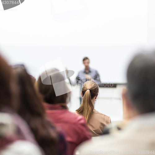 Image of Public speaker giving talk at Business Event.