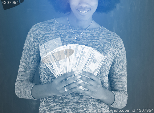 Image of black woman holding money on gray background