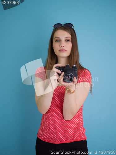 Image of beautiful girl taking photo on a retro camera