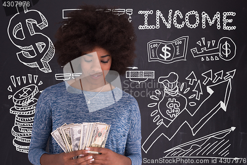 Image of black woman holding money on gray background