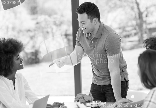 Image of Young businessman with his team at work