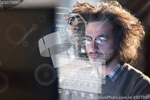 Image of man working on computer in dark office