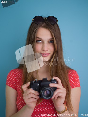 Image of beautiful girl taking photo on a retro camera