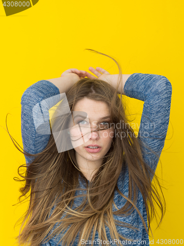 Image of pretty woman playing with her long silky hair