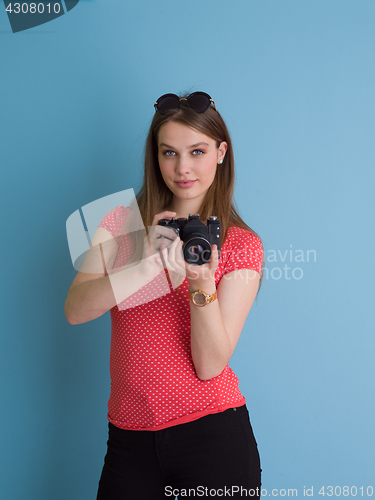 Image of beautiful girl taking photo on a retro camera