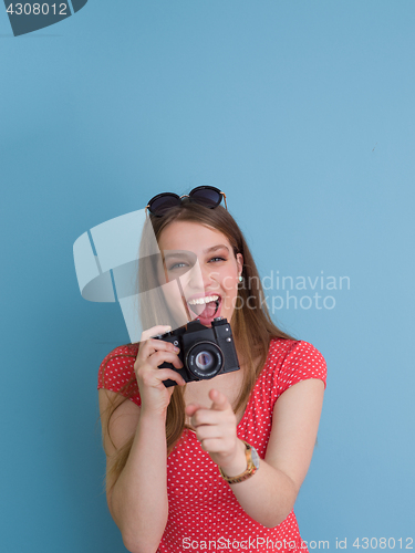 Image of beautiful girl taking photo on a retro camera