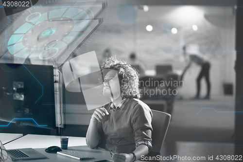 Image of man working on computer in dark office