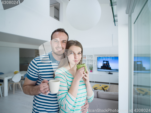 Image of young handsome couple enjoying morning coffee