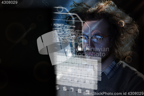 Image of man working on computer in dark office