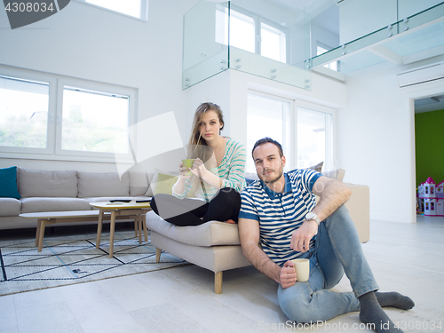 Image of young handsome couple enjoying morning coffee