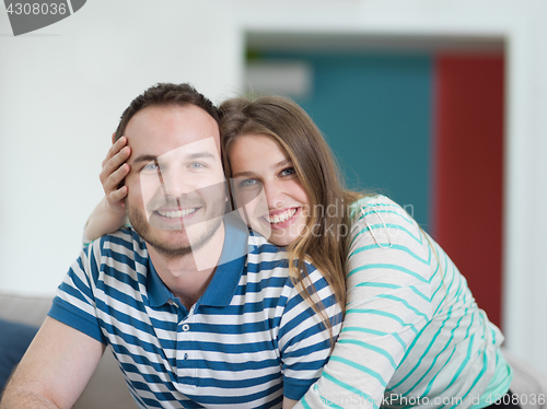 Image of young handsome couple hugging on the sofa