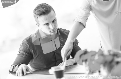 Image of Businesswoman showing a paper to her colleague