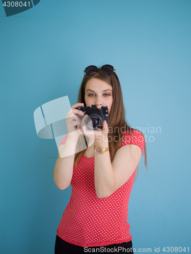 Image of beautiful girl taking photo on a retro camera