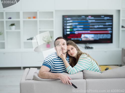 Image of Young couple on the sofa watching television