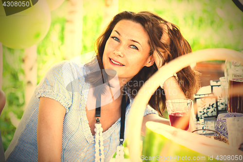 Image of smiling beautiful woman at a table at a party