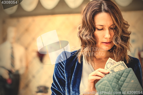 Image of woman counting cash in her wallet