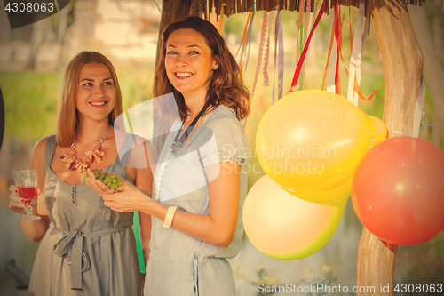 Image of Two beautiful cheerful women at a picnic