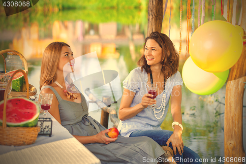 Image of Two beautiful cheerful women at a party