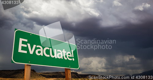 Image of Evacuate Green Road Sign and Stormy Clouds