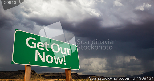 Image of Get Out Green Road Sign and Stormy Clouds