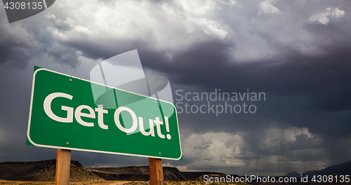 Image of Get Out Green Road Sign and Stormy Clouds