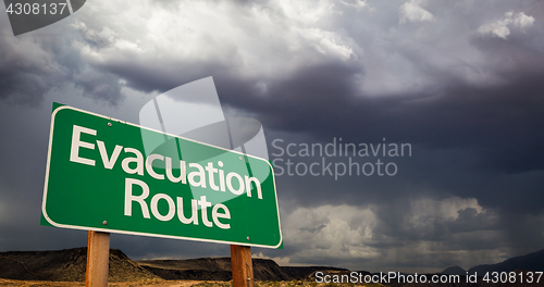 Image of Evacuation Route Green Road Sign and Stormy Clouds