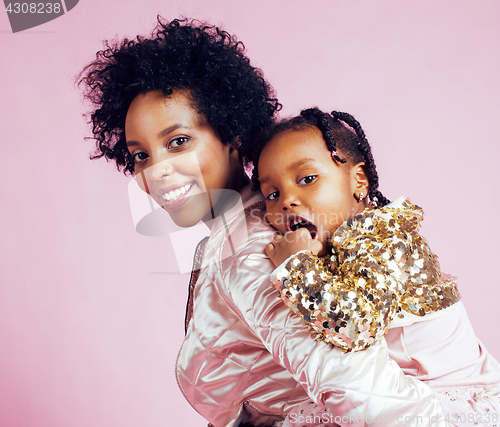 Image of young pretty african-american mother with little cute daughter hugging, happy smiling on pink background, lifestyle modern people concept 