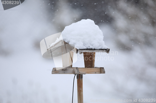 Image of simple bird feeder in winter garden