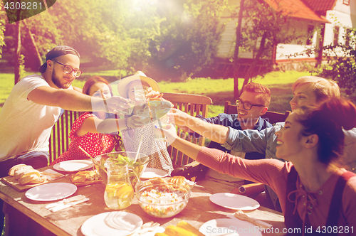 Image of happy friends having dinner at summer garden party