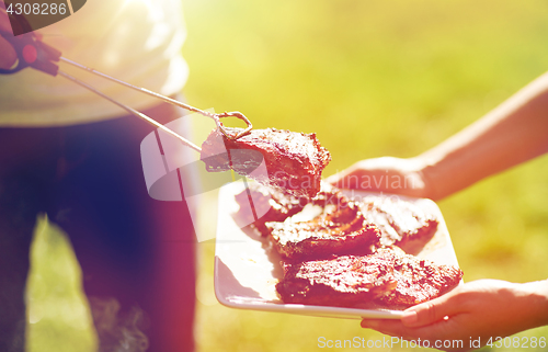 Image of man cooking meat at summer party barbecue