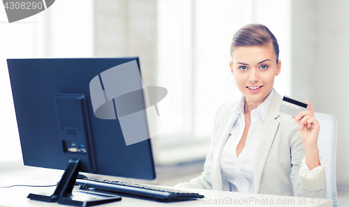 Image of businesswoman with computer using credit card