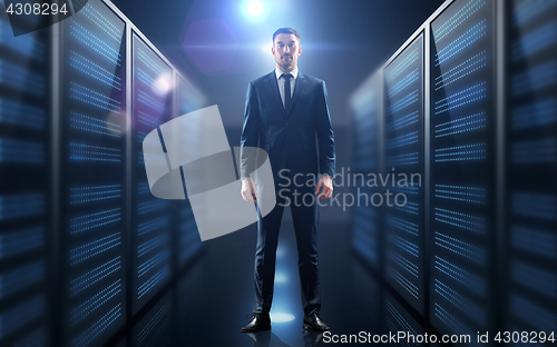 Image of businessman over server room background