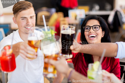 Image of friends clinking glasses with drinks at restaurant