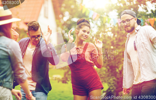 Image of happy friends dancing at summer party in garden