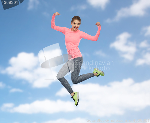 Image of happy smiling sporty young woman jumping in sky