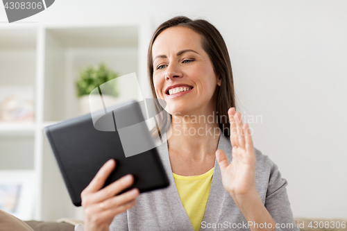 Image of happy woman having video chat on tablet pc at home