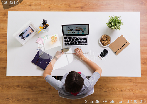 Image of woman with laptop and credit card at table