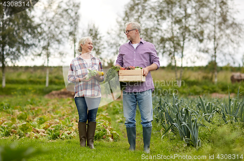 Image of senior couple with box of vegetables on farm