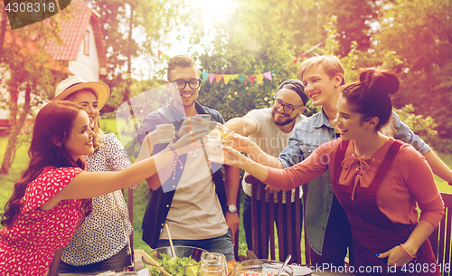 Image of happy friends having party at summer garden