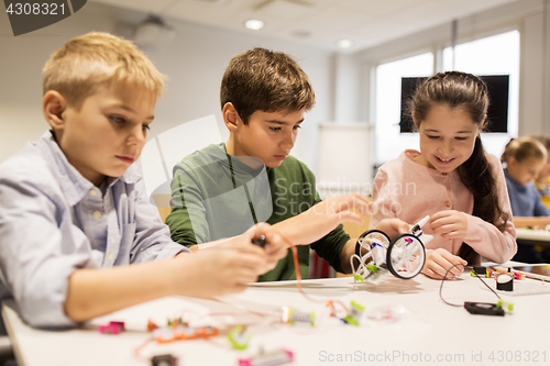 Image of happy children building robots at robotics school