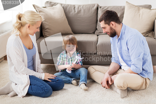 Image of happy family playing with toy wind turbine