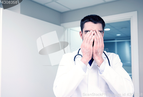 Image of sad or crying male doctor at hospital ward