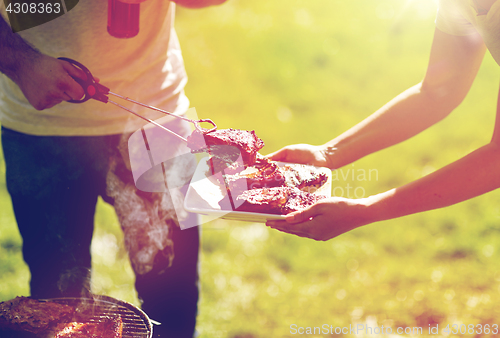 Image of man cooking meat at summer party barbecue