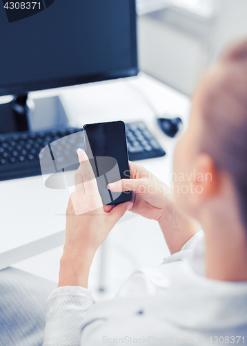 Image of businesswoman with smartphone in office