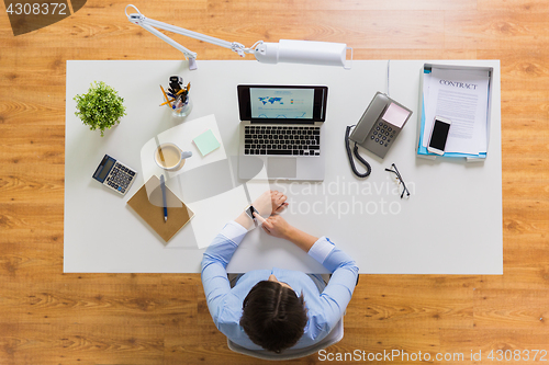 Image of businesswoman working on laptop at office