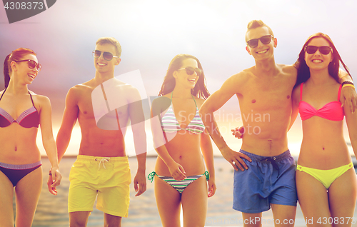 Image of smiling friends in sunglasses on summer beach