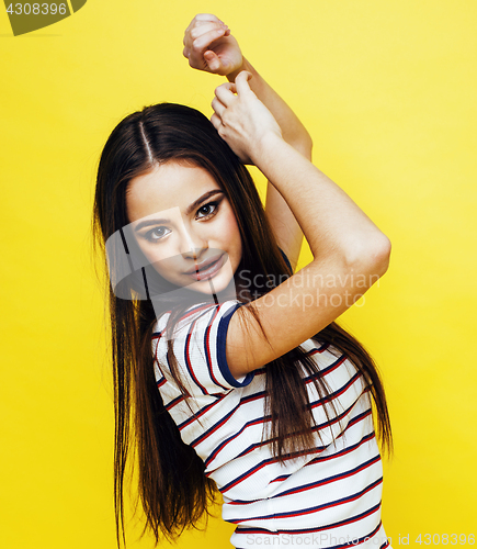 Image of young pretty teenage woman angry posing on yellow background, fashion lifestyle people concept 